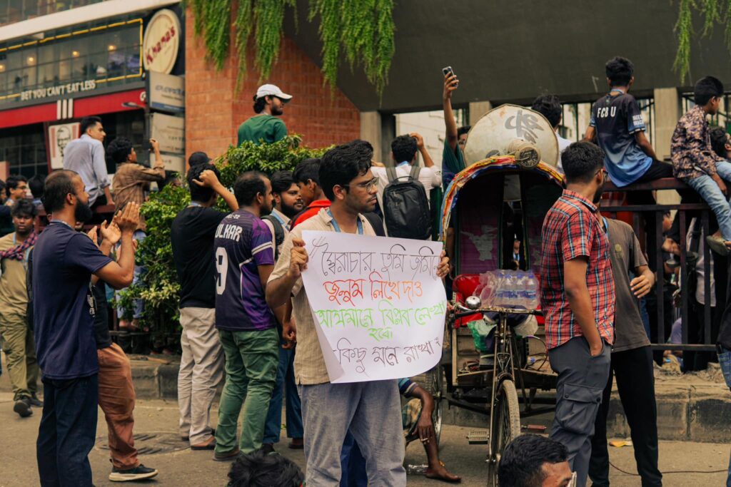 A student with a poster demanding the end of the oppression by the dictator